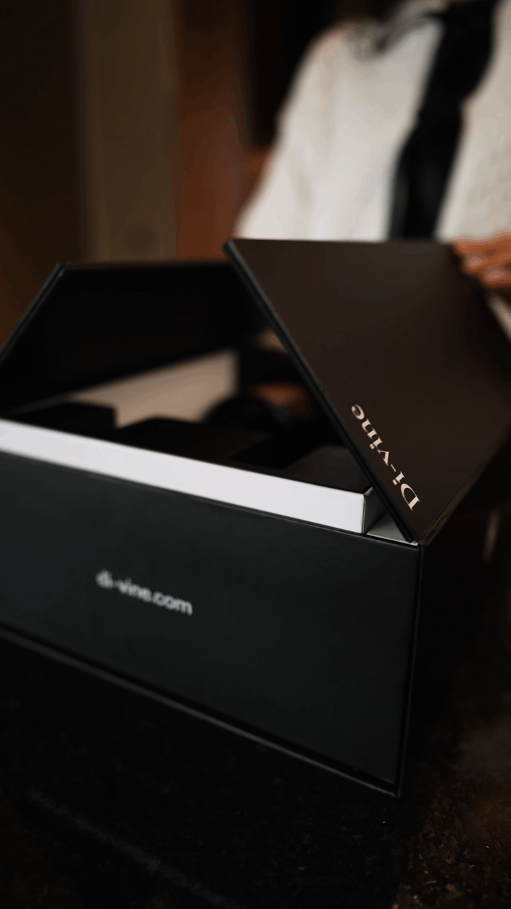 Close up video of a woman opening the doors of a “Di-vine” elevator gift box, with l the inner box rising up as the doors get wider.
