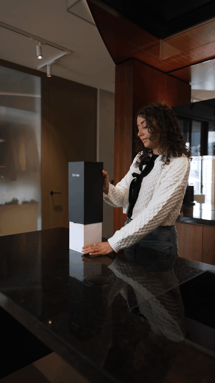 Video of a woman at a kitchen island lifting the top off a “Di-vine” gift box, revealing the bottle of wine inside.