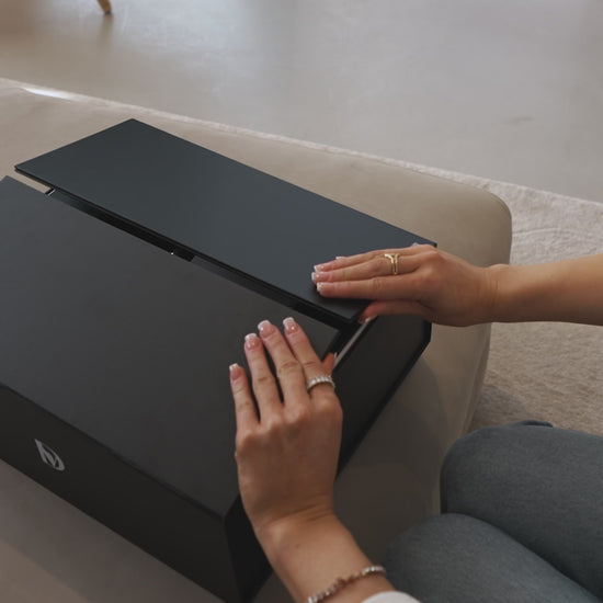 Video looking down on a woman’s hands opening the doors of a “Di-vine” elevator gift box and seeing a bottle of “Di-vine” red and a bottle if “Di-vine” white inside. 